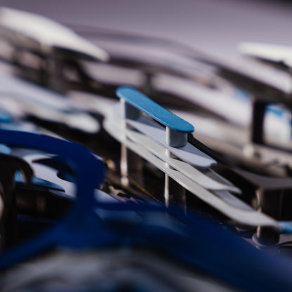 Close-up of a blue car model with lots of metal connectors with a blurred background