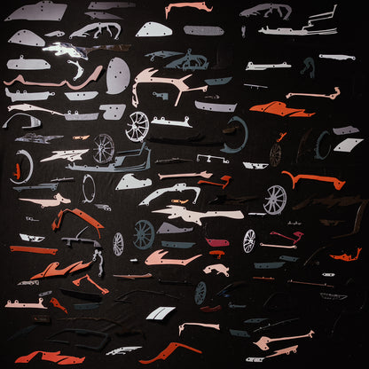 Collection of red car model panels and parts on a black background
