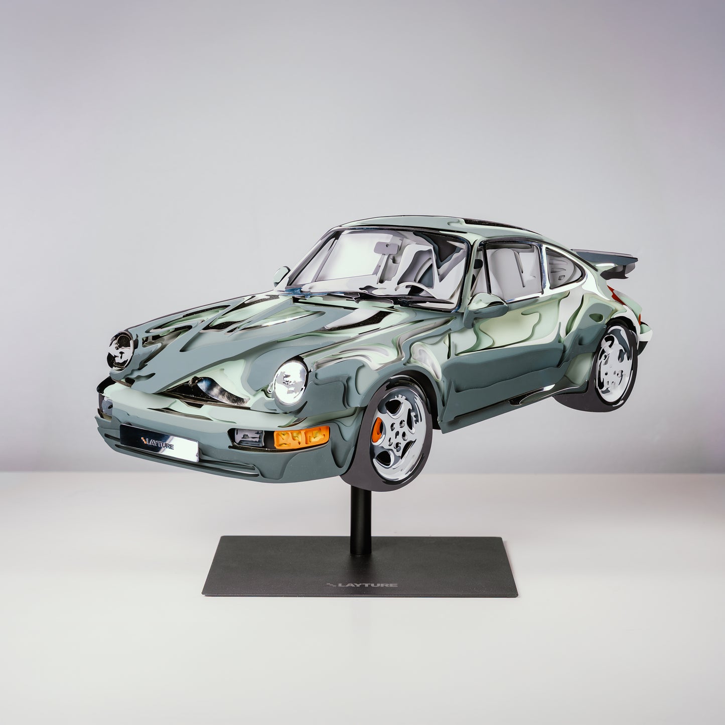 Model of a green sports car on a stand against a gray background