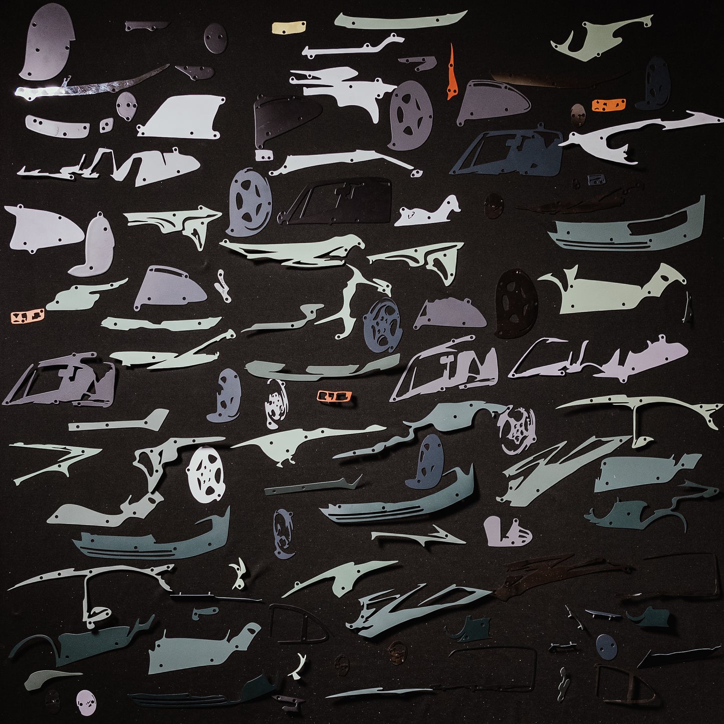 Collection of green car model panels and parts on a black background