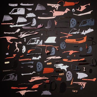 Collection of red car model panels and parts on a black background
