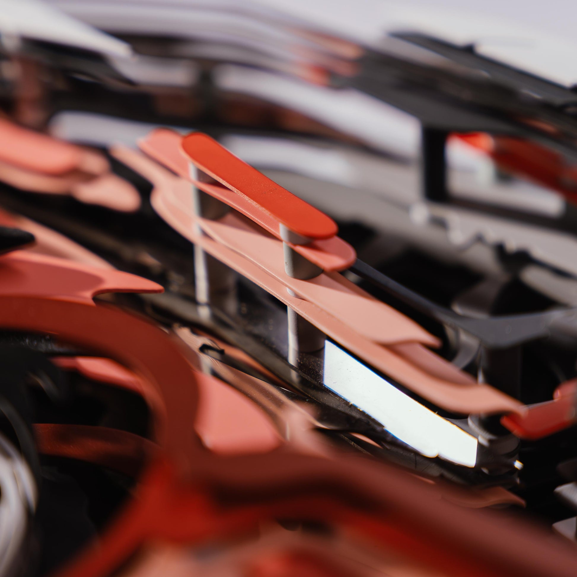Close-up of a red car model with lots of metal connectors with a blurred background