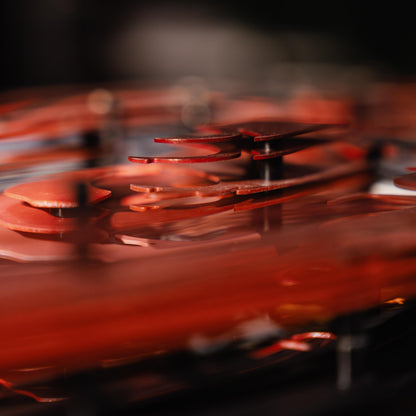 Close-up of a red car model with lots of metal connectors with a blurred background